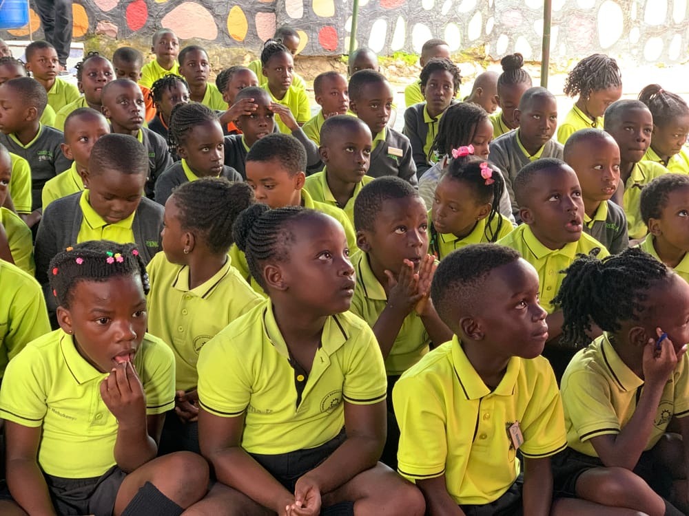 The whole school seated at assembly under the tent